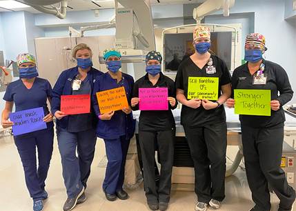 staff holding thank you signs