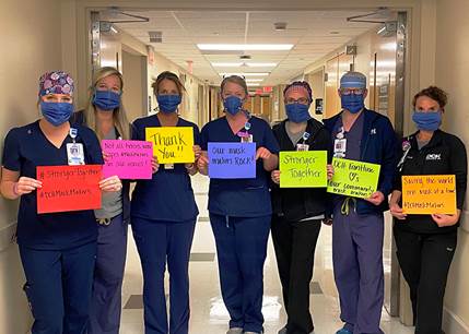 staff holding thank you signs